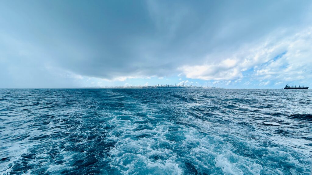 Oceano tempestuoso sob nuvens escuras, cenário de bandeira vermelha de navegação