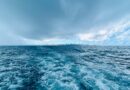 Oceano tempestuoso sob nuvens escuras, cenário de bandeira vermelha de navegação